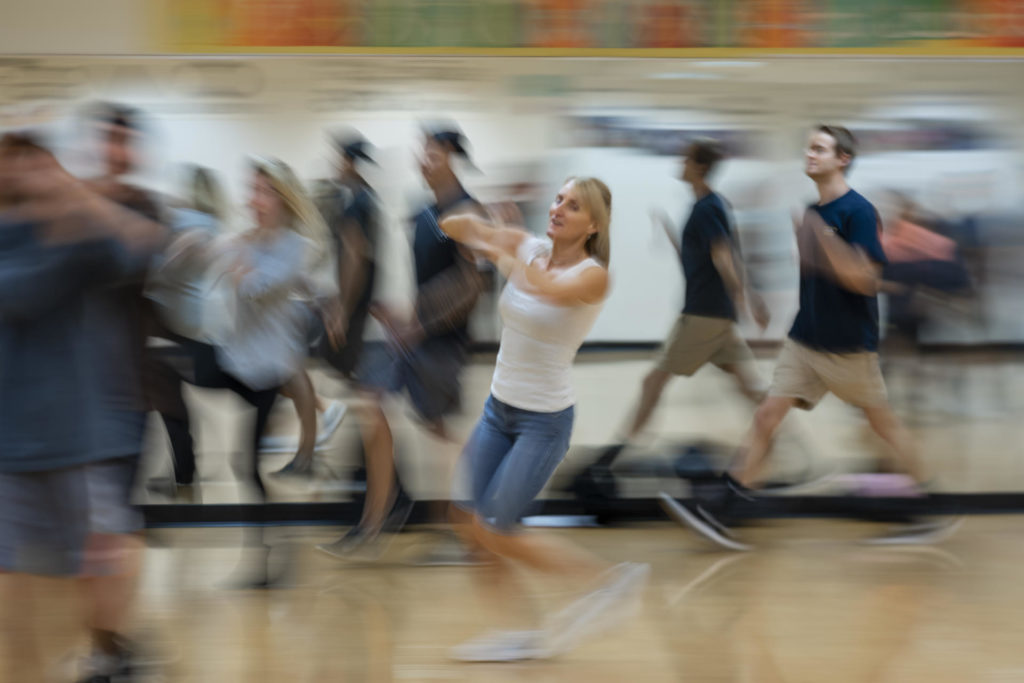 Cathrine Himberg moves through a blurry group of students in movement