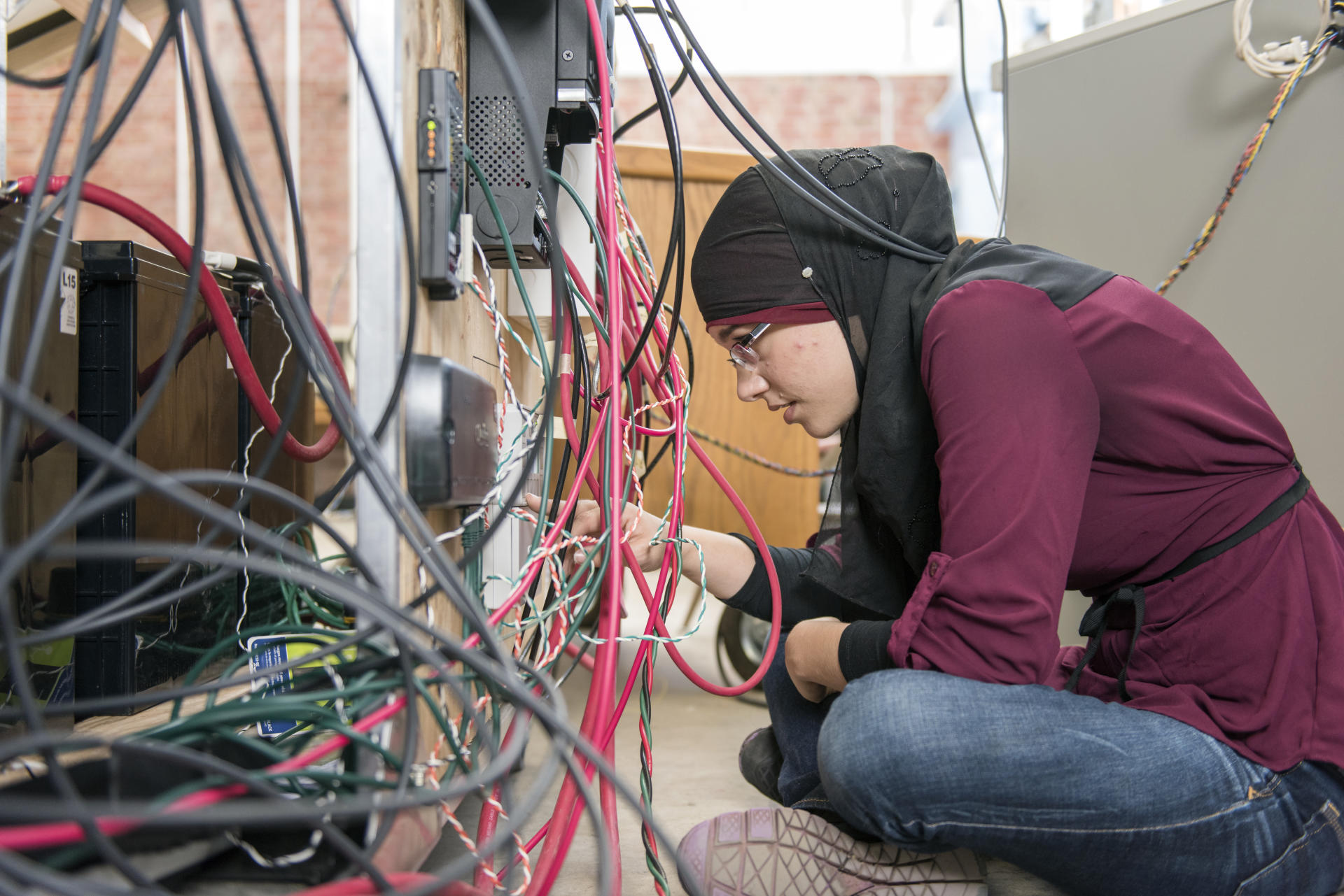 Salam Ali runs tests on her solar charging station in Langdon Hall on Thursday, April 21, 2016 in Chico, Calif. Ali is a part of Society of Women Engineers, has managed the climbing wall at the WREC, held/organized Muslim events on campus, and is participating in Capstone Engineering Project program. (Jason Halley/University Photographer)