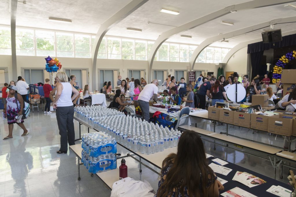 Rows of water bottles line a gymnasium table to be handed out to more than 150 families. 