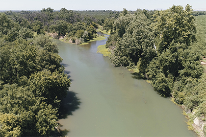 Aerial view of the Sacramento River and a side channeling splitting off between the trees.