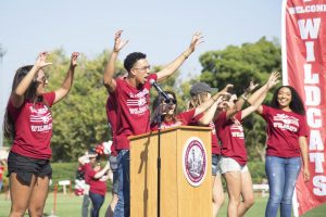 Dylan Gray speaks at a podium to welcome new students to Chico State.