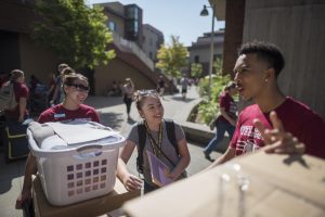 Dylan Gray helps a student move into her new dorm room outside of Whitney Hall.