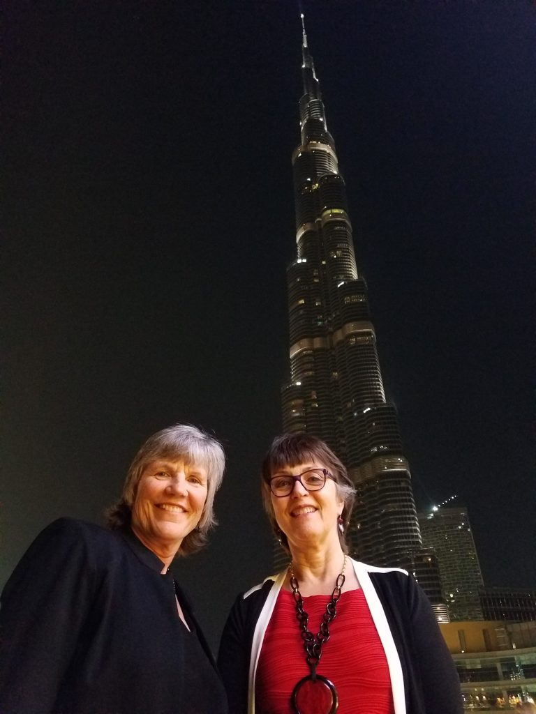 President Hutchinson and her wife, Linda, stand together in front of the world's tallest building, lit up in the night sky.