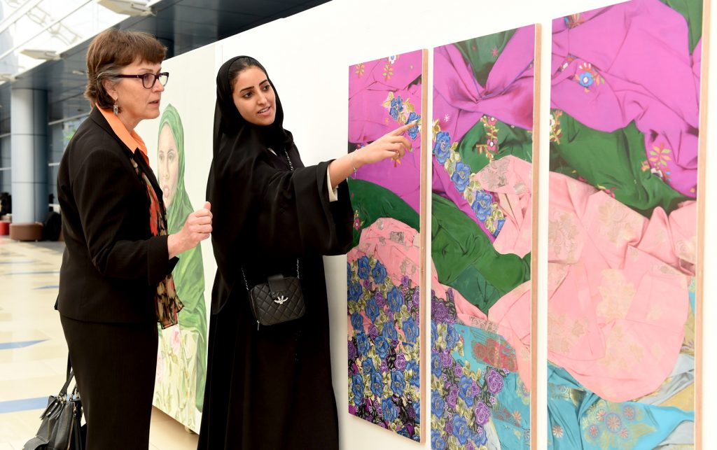 A student artist shows off one of her pieces during a tour of Zayed University's student union. 
