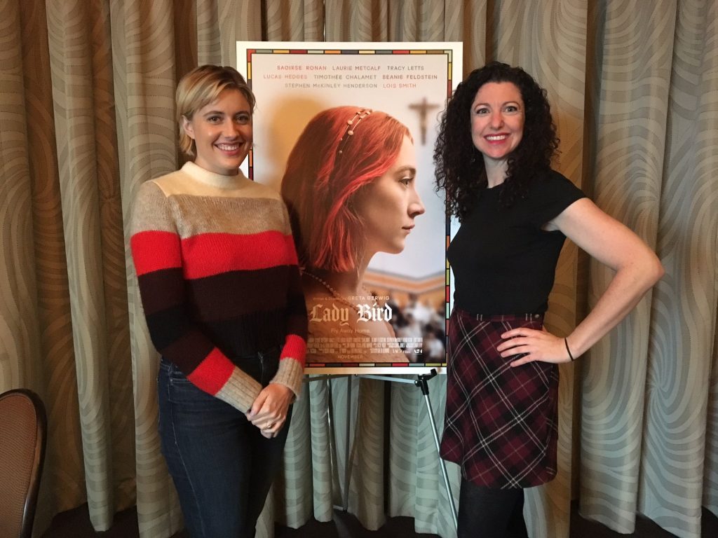 Rachel Belle poses with film director Greta Gerwig in front of a poster for the film Lady Bird.