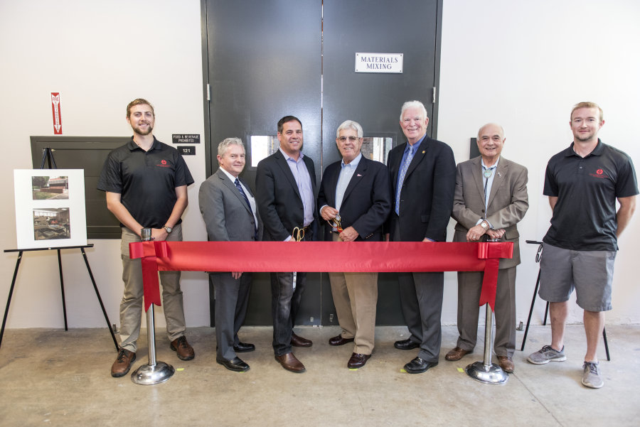 Murphy and other patrons stand at a ribbon-cutting for the concrete lab.