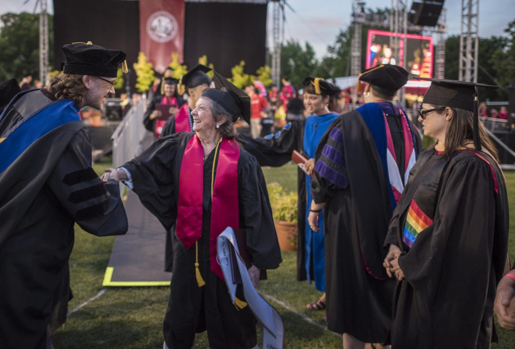 Sylvia Hamilton shakes hands with faculty after walking the stage.