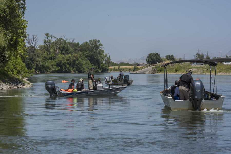 Two boats with Chico State faculty and graduate students idle in the Sacramento River.