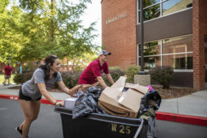 Students push move-in bins by Lassen Hall 