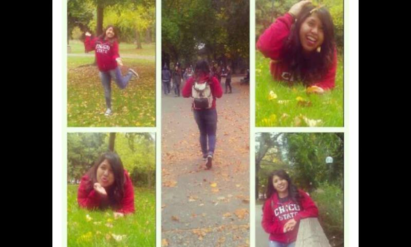 Student in Chico State sweatshirt poses around campus with fall leaves