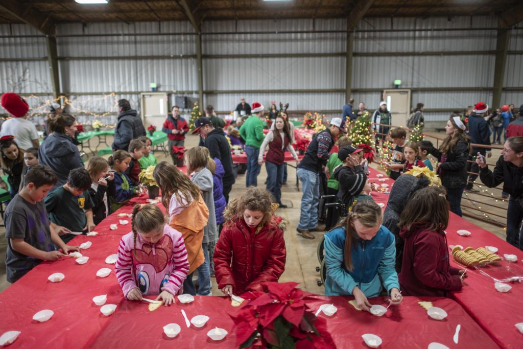 Students fill both sizes of banquet tables to frost cookies in the University Farm Pavilion.