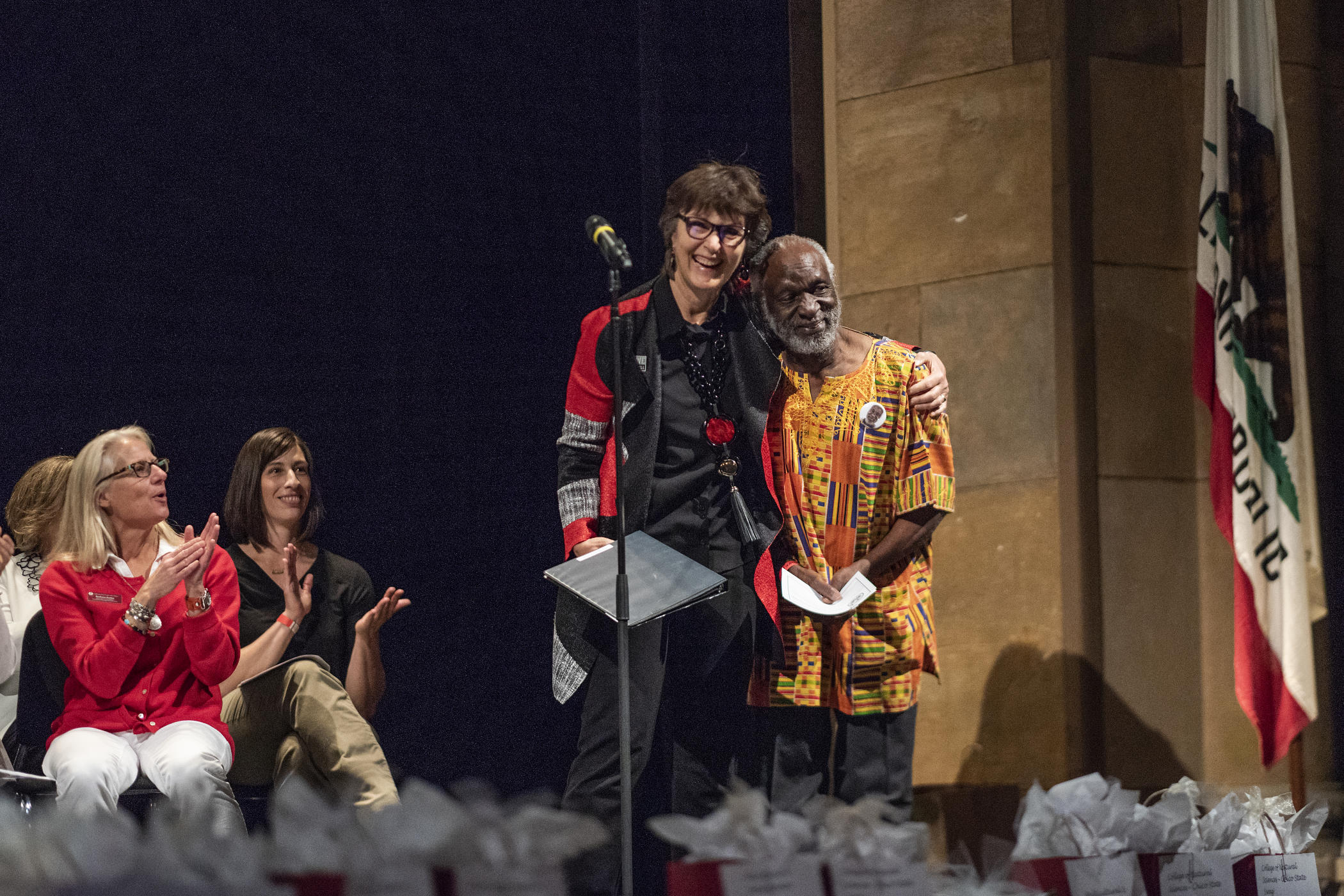 President Gayle Hutchinson (left) recognizes James Luyirika-Sewagudde, Jr., (right) for 45 years of service as staff are honored during the Staff Awards Luncheon in May 2018.
