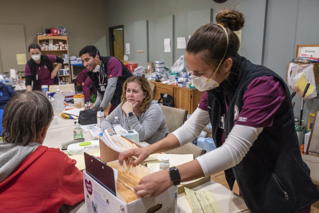 Nursing students help patients at an evacuation shelter by taking their vital information, searching through files, and offering a smile.