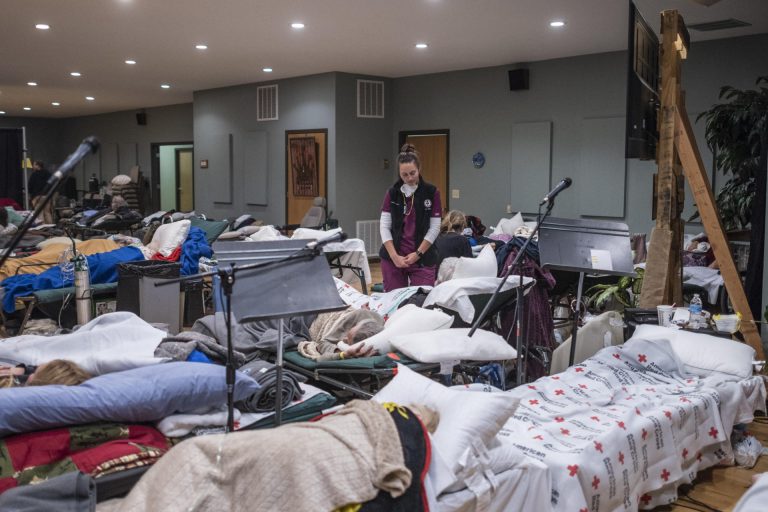 Jennifer Lefort stands among rows of beds set up at the Neighborhood Church evacuation center.