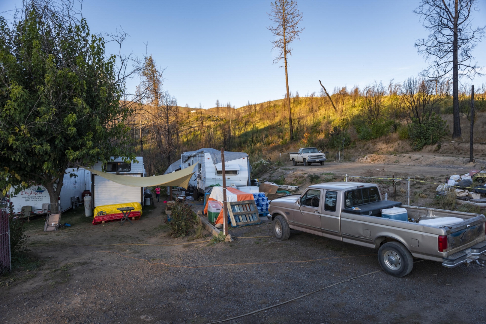 Vehicles and travel trailers occupy a yard.