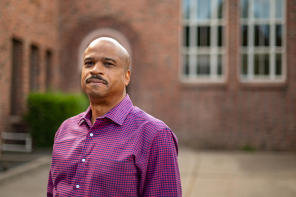 Tray Robinson poses in front of an academic building.