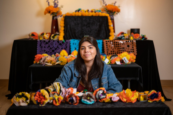 Student Guadalupe Cruz sits in front of her Dia de los Muertos altar she set up at the Valene L. Smith Museum of Anthropology.