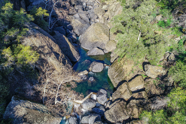 A drone shot of a canyon and creek