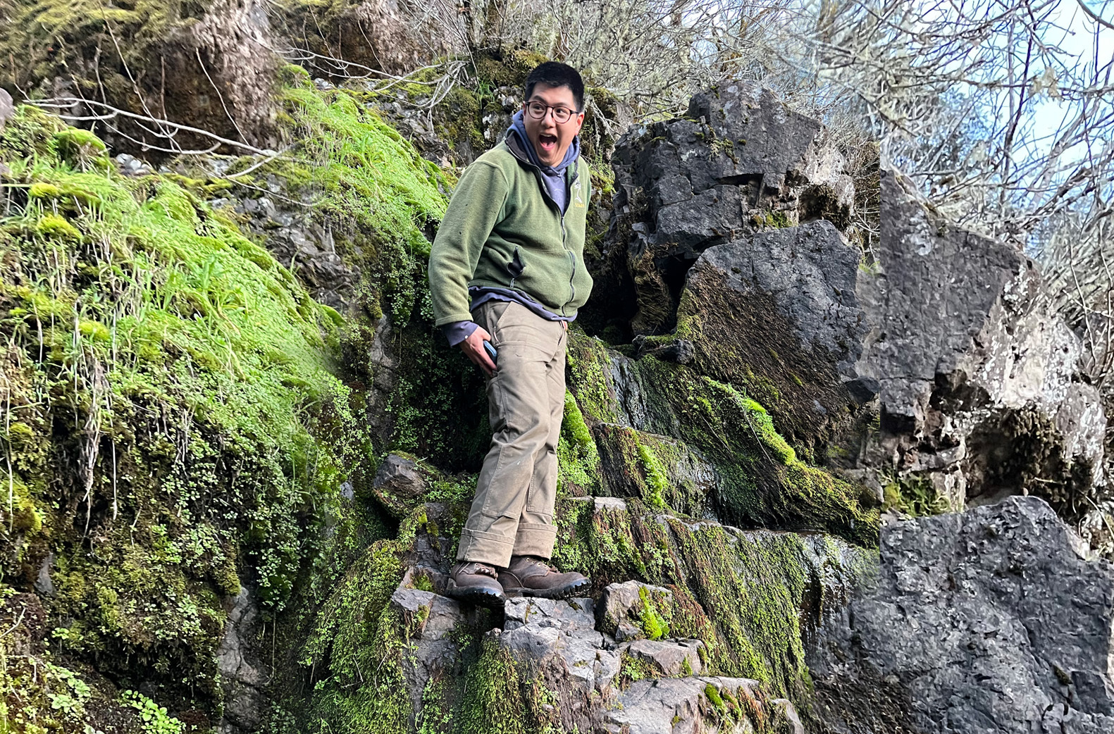 Ben Chang stands on rocks and smiles because he likes it so much