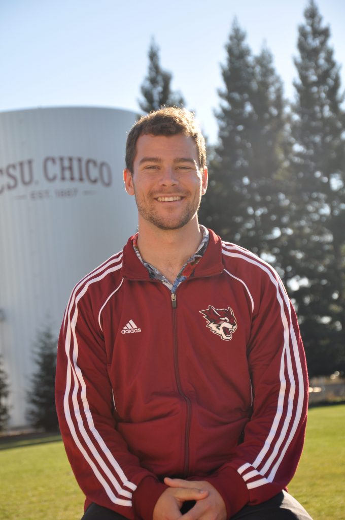 Portrait of Dylan Smith in Wildcats gear with CSU, Chico water tower in background.