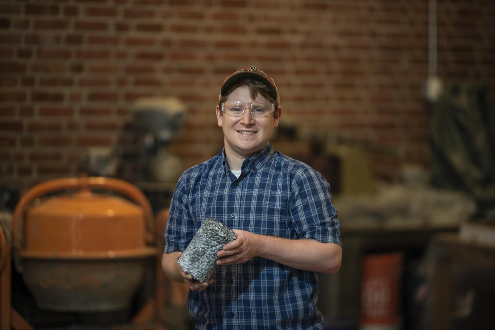 Portrait of Tim O'Shea holding a cylinder of concrete