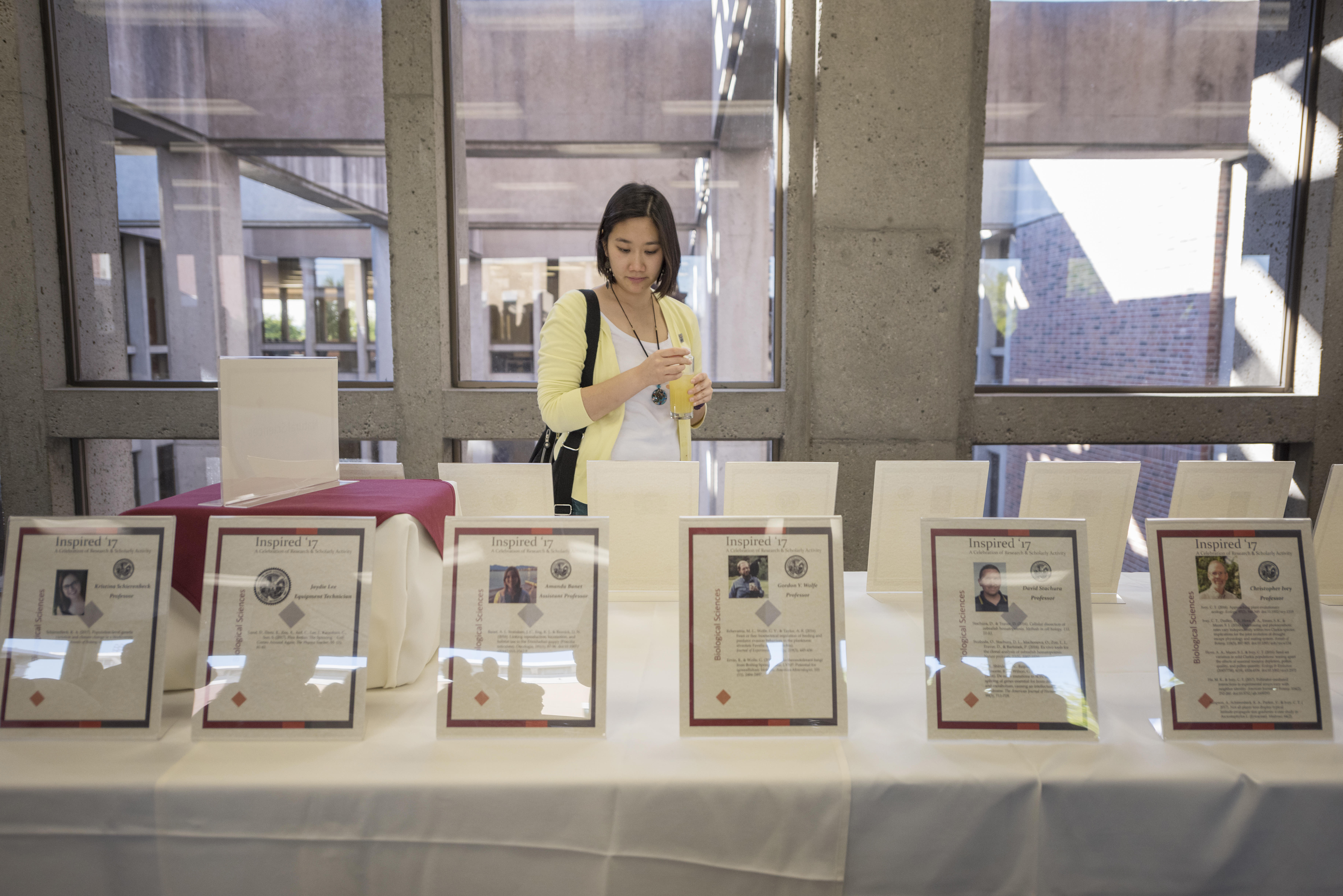 Department of Chemistry and Biochemistry Professor Monica So looks at a display of faculty publications during Inspired '17, the University's inaugural celebration of publication achievements of faculty, staff, and personnel.