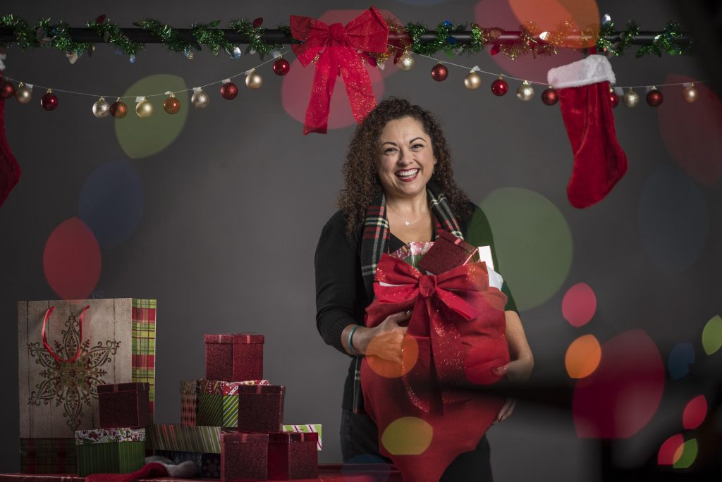 Portrait of Lisa Saldano holding holiday gifts.
