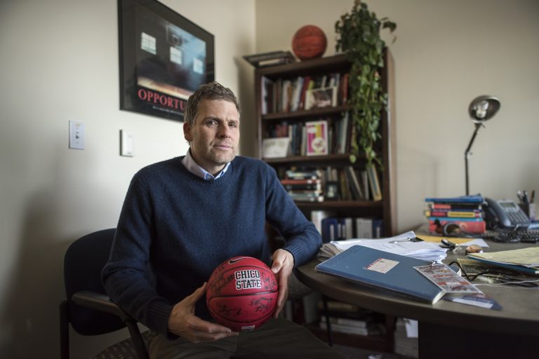 Carson Medley holding a basketball in his office