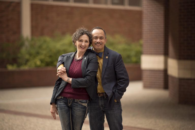 Renee Renner (left) and Ben Juliano (right) hold hands and pose for a photo on the Chico State campus.