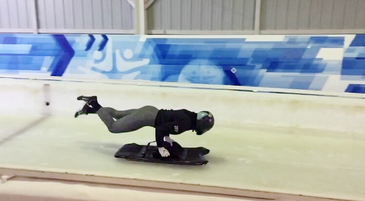 Brooke is mid-air as she jumps onto a skeleton sled