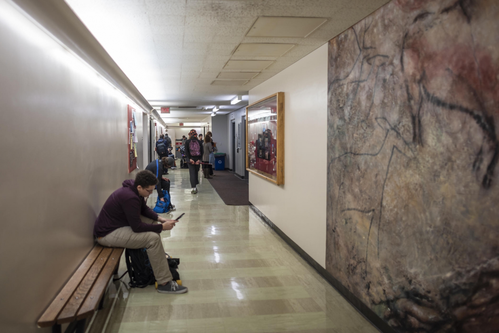 Students sit in the hallway of Butte Hall while waiting for class to start.