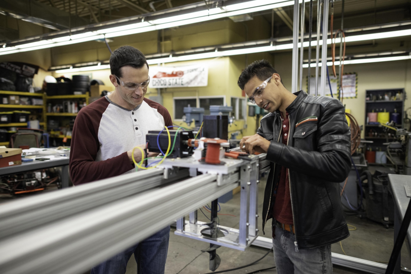 Two students work on their large-scale 3-D printer that will build homes out of concrete.
