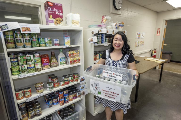 Yee Yang holds up some of the food that the Hungry Wildcat Food Pantry provides nutritious food, CalFresh food program assistance and referral services for students experiencing food insecurity.