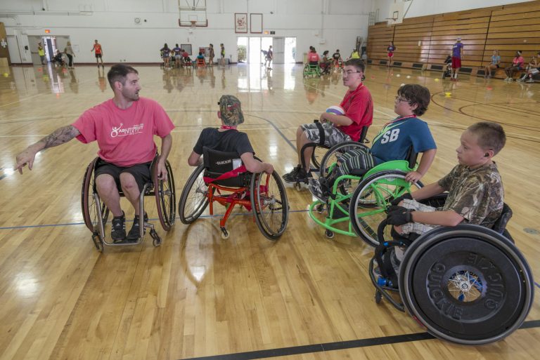 Devon Saul instructs his students in basketball at the annual Ability First Sports Camp, a sports and recreation instructional summer camps for children ages 8 to 17 with physical disabilities. Chico State plays host to many of the camp events and faculty and its Department of Recreation, Hospitality, and Parks Management provides staffing support for the camp.