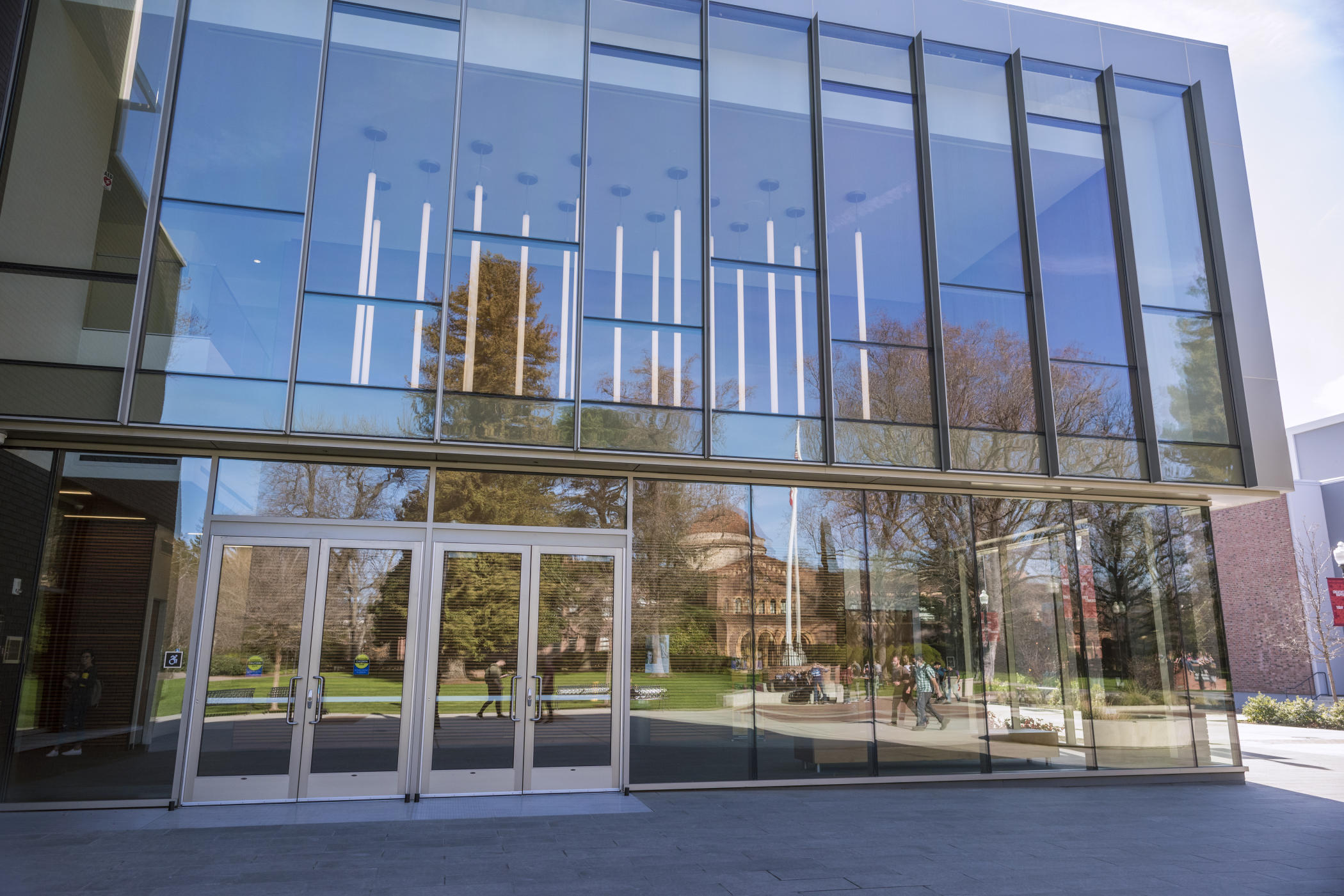 Kendall Hall is reflected in the front windows of the Arts and Humanities building on a winter morning.