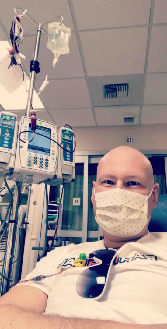 Slade Giles wears a mask while connected to tubes at a chemotherapy appointment.