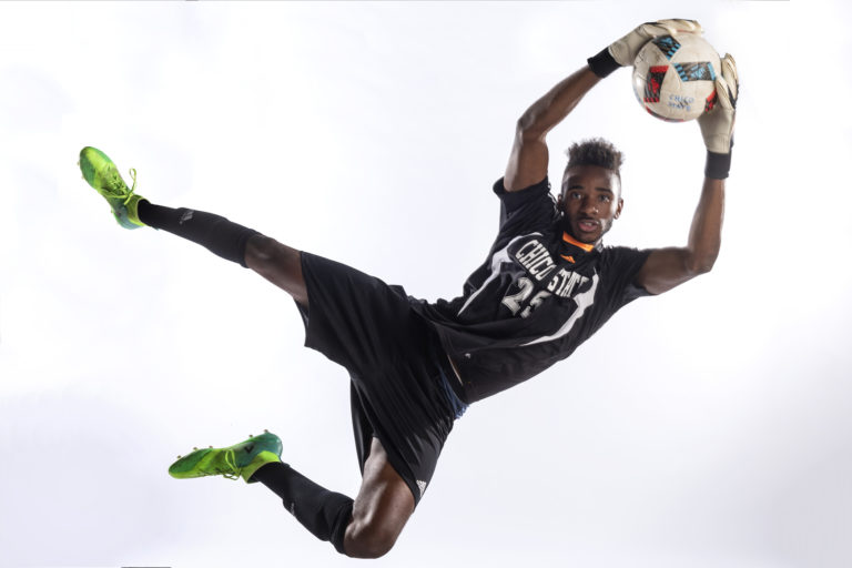 Damion Lewis jumps to catch a soccer ball during a photoshoot