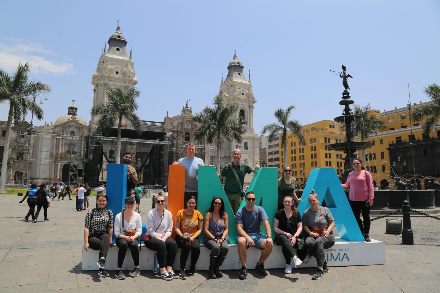 Students pose with cut-out letters that spell "LIMA"