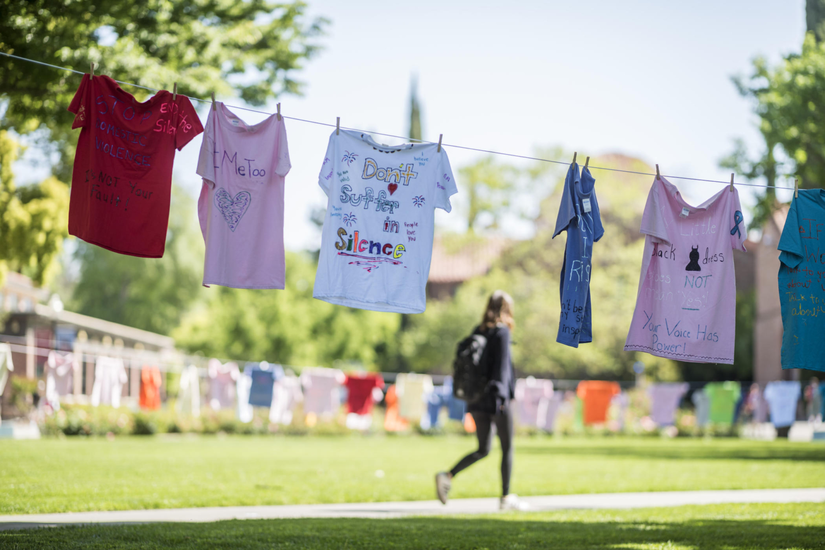 T-shirts hang on campus with messages like "don't suffer in silence" and "#metoo" and "stop domestic violence. it's not your fault."