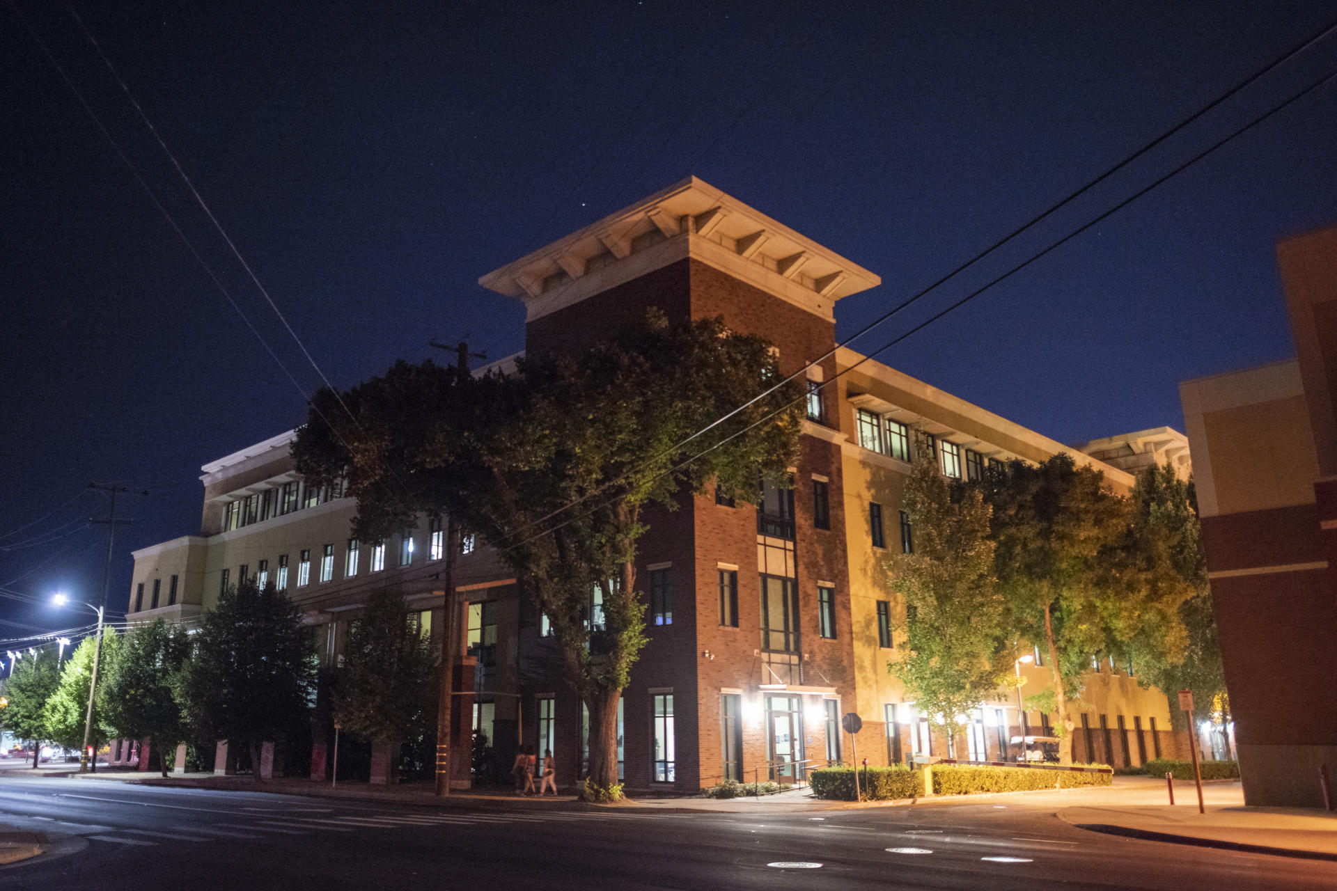 The Student Services Center is photographed at night. Street lights illuminate the walkways around the building.