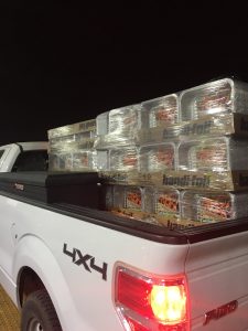 A pallet of aluminum foil pans sits in the back of a truck at night.