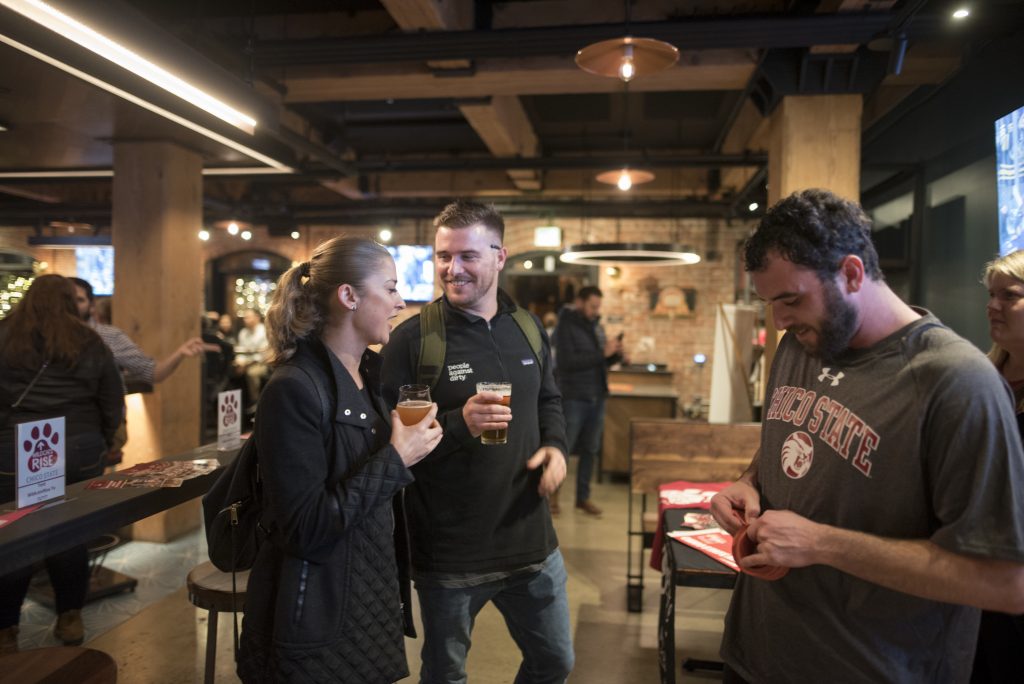 Three people drink Resilience IPA in the San Francisco Brewing Co. taproom.