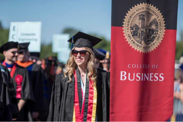 A college of Business graduate poses in cap and gown.