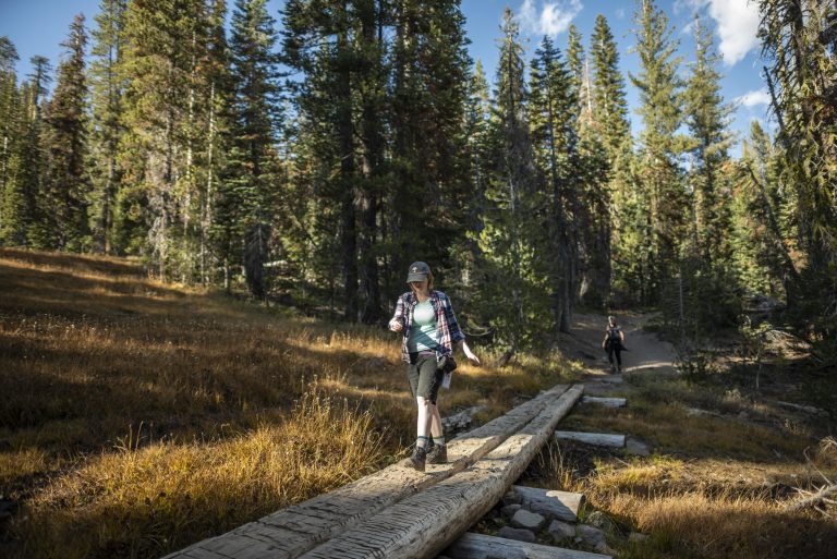 Chico State students hike across a narrow bridge in Lassen Volcanic National Park on an Adventure Outings backpacking trip.