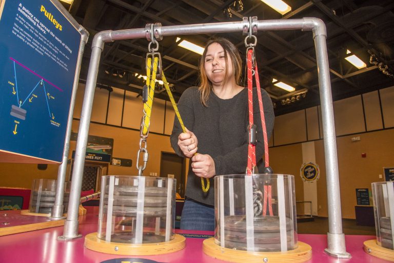 A Chico State student works with a pulley display at the Gateway Science Museum's newest exhibit.