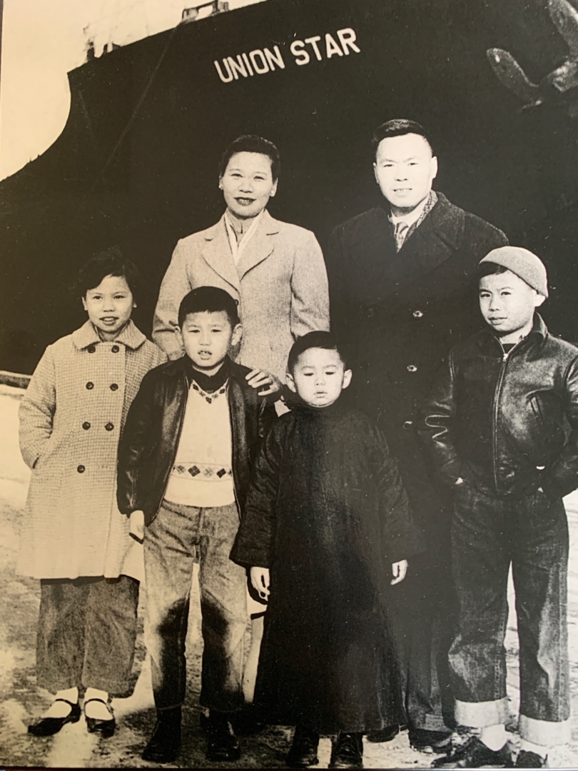 A Chinese immigrant family pose in front of the ship that brought them to the United States