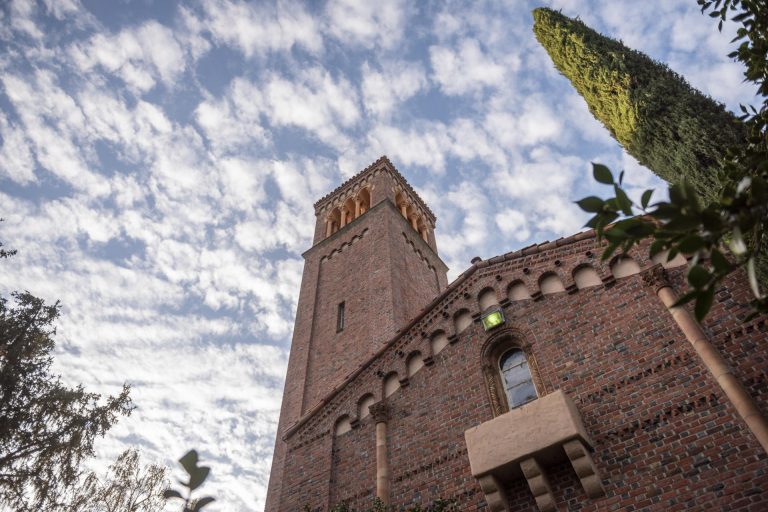 The bell tower of Trinity Hall rises into the clouds on a beautiful fall morning on the Chico State campus.