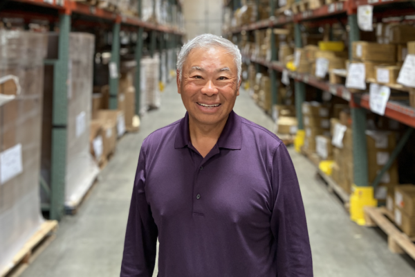 Portrait of Norman Tu standing in a warehouse