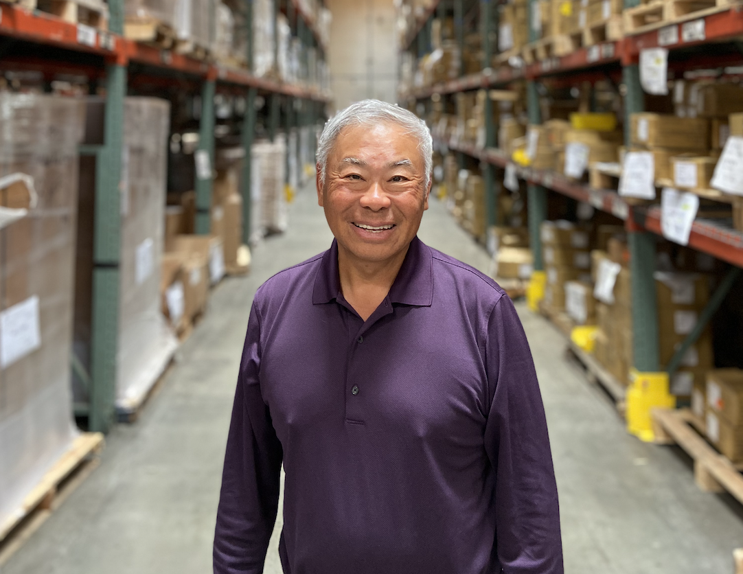 Portrait of Norman Tu standing in a warehouse