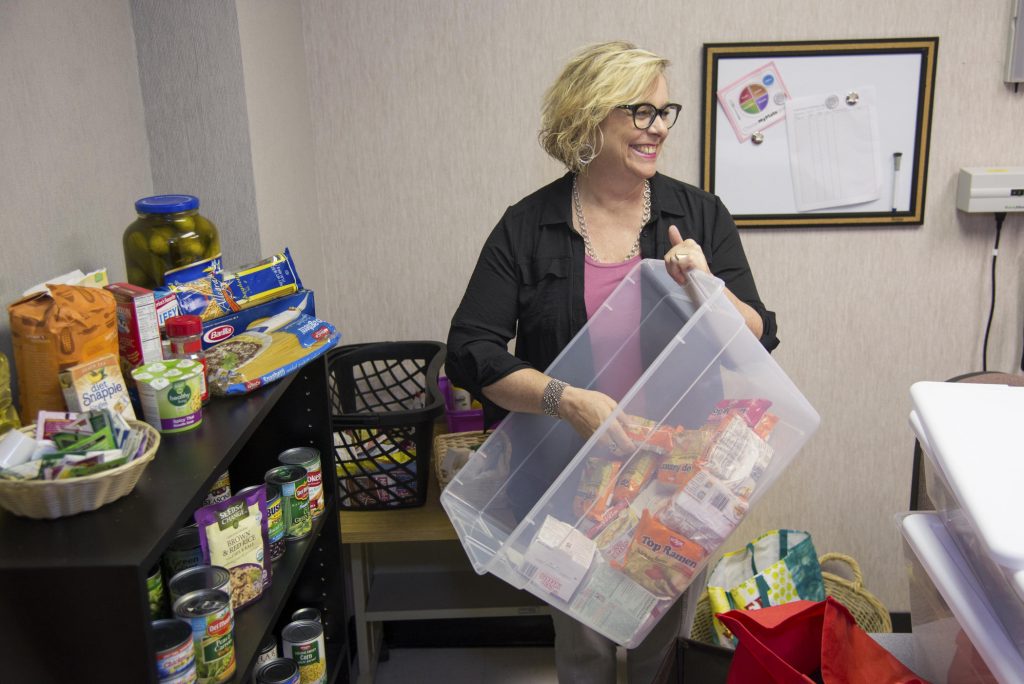 Kathleen Moroney stocks the shelves of the Hungry Wildcat Food Pantry.